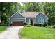 Charming single-story home featuring a manicured lawn, blue siding, and an attached two-car garage at 2133 Highland View Ln, Charlotte, NC 28214