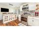Bright kitchen with breakfast bar, stainless steel appliances, open shelving, and beautiful wood floors at 2133 Highland View Ln, Charlotte, NC 28214