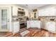 Charming kitchen features white cabinetry, stainless appliances, and unique backsplash and wood-look flooring at 2133 Highland View Ln, Charlotte, NC 28214