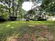 Backyard showcasing a blend of open grassy space, mature trees, and shed, perfect for outdoor living at 2411 Rebecca Ave, Charlotte, NC 28208