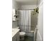 All-white bathroom featuring a shower with a geometric curtain, vanity, toilet, and hanging plants at 2411 Rebecca Ave, Charlotte, NC 28208