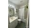 Bathroom featuring a shower with a geometric curtain, vanity, toilet, hanging plant, and a mirrored wall at 2411 Rebecca Ave, Charlotte, NC 28208