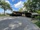 Home with a covered carport surrounded by gravel and lush landscaping at 2411 Rebecca Ave, Charlotte, NC 28208
