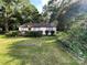 Single-story home features manicured hedges and a garden bed, nestled on a green lawn at 2411 Rebecca Ave, Charlotte, NC 28208