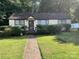 Charming single-story home with a well-manicured lawn and established landscaping at 2411 Rebecca Ave, Charlotte, NC 28208