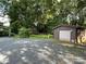 Detached garage with a driveway, surrounded by lush greenery, offering ample storage at 2411 Rebecca Ave, Charlotte, NC 28208