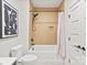 Bathroom with shower-tub combo featuring neutral-toned tile and black hardware at 2733 Cowles Rd, Charlotte, NC 28208