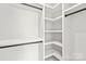 Walk-in closet with built-in shelving, dark rods and white walls at 2733 Cowles Rd, Charlotte, NC 28208
