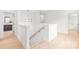 Hallway with light hardwood floors leading to an open bathroom with a staircase at 2733 Cowles Rd, Charlotte, NC 28208