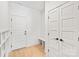 Bright mudroom space with white doors, shiplap accent wall, built-in bench, and hardwood floors at 2733 Cowles Rd, Charlotte, NC 28208