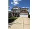 Charming two-story home boasts a manicured lawn and inviting facade with stone and gray siding and a two car garage at 2810 Shumard Dr, Gastonia, NC 28054