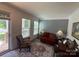 Inviting living room features a red sofa, area rug, neutral walls, and natural light from the nearby door and windows at 2810 Shumard Dr, Gastonia, NC 28054