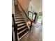 Elegant staircase with dark wood and white risers, complemented by stylish decor and ample natural light at 2810 Shumard Dr, Gastonia, NC 28054