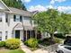 Charming townhome featuring a covered porch, a brick facade, lush landscaping, and a well-manicured front yard at 3414 Broadwick St, Charlotte, NC 28213
