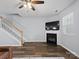 Cozy living room with a fireplace, staircase, large window, and hardwood floors at 3414 Broadwick St, Charlotte, NC 28213
