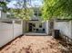 Back patio with a small table and chairs, wood mulch, white fencing, and attached storage unit at 3414 Broadwick St, Charlotte, NC 28213