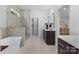 Bright bathroom featuring a modern tub, glass enclosed shower, stylish vanity and an open door to a closet at 3701 Table Rock Rd, Charlotte, NC 28226