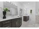 Bright bathroom showcases double vanities with dark cabinets, white countertops and modern fixtures with a tiled shower in the background at 3701 Table Rock Rd, Charlotte, NC 28226