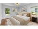 Staged bedroom featuring natural light, hardwood floors, and art-adorned walls at 3701 Table Rock Rd, Charlotte, NC 28226