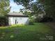 Expansive backyard featuring a detached garage, lush grass, and mature trees, perfect for outdoor enjoyment at 4032 Wilgrove Way Dr # 252, Charlotte, NC 28213