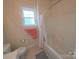 Bathroom featuring a tub/shower combo with a floral shower curtain, complemented by coral towels and natural light at 4032 Wilgrove Way Dr # 252, Charlotte, NC 28213
