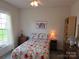 Charming bedroom with a floral-patterned quilt, bedside tables, and ample natural light from the window at 4032 Wilgrove Way Dr # 252, Charlotte, NC 28213
