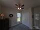 This bedroom features a ceiling fan, a large window, and a closet door offering ample storage at 4032 Wilgrove Way Dr # 252, Charlotte, NC 28213