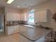 Well-lit kitchen featuring white cabinetry, tile flooring and ample counter space at 4032 Wilgrove Way Dr # 252, Charlotte, NC 28213