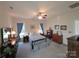 Spacious bedroom with ceiling fan, neutral walls, blue curtains, carpet flooring, dressers and shelving at 4032 Wilgrove Way Dr # 252, Charlotte, NC 28213