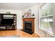 Living room fireplace with wooden mantle, decorative plants, and a TV console at 4068 Sherri Ln, Fort Mill, SC 29715