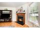 Living room fireplace with wooden mantle, decorative plants, and a TV console at 4068 Sherri Ln, Fort Mill, SC 29715
