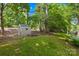 Large, grassy backyard featuring a storage shed, mature trees, and landscaping at 4313 Wynborough Ln, Charlotte, NC 28269