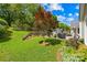 Lush backyard with patio area, shed, mature trees, and serene landscaping at 4313 Wynborough Ln, Charlotte, NC 28269
