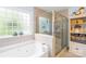 Bright bathroom with a bathtub, separate glass shower, and light blue walls at 4313 Wynborough Ln, Charlotte, NC 28269