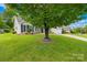Landscaped front yard with a large shade tree, lush lawn and inviting curb appeal at 4313 Wynborough Ln, Charlotte, NC 28269