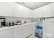 Bright laundry room with white cabinets, countertop space, washer and dryer at 4313 Wynborough Ln, Charlotte, NC 28269