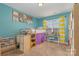 bedroom with a lofted bed and a desk area, complemented by bright turquoise walls and yellow striped curtains at 460 Clouds Way, Rock Hill, SC 29732