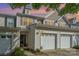 Charming townhome with attached two-car garage, complemented by manicured landscaping and warm exterior lighting at 460 Clouds Way, Rock Hill, SC 29732