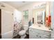 Bathroom with neutral walls, toilet, white vanity, shower and tub combination with floral curtains at 4703 David Cox Rd, Charlotte, NC 28269