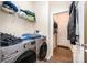Functional laundry room with stainless steel washer and dryer, storage shelf, and wood-look floors at 4703 David Cox Rd, Charlotte, NC 28269