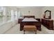 Cozy bedroom featuring a dark wood bed frame, neutral walls, and large windows for ample natural light at 4966 Riverview Dr, Harrisburg, NC 28075