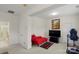 Bonus room featuring a red chaise lounge, TV, and access to an additional room with a shower at 4966 Riverview Dr, Harrisburg, NC 28075