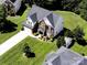 Aerial view of a two-story brick and siding home with a manicured lawn and driveway at 4966 Riverview Dr, Harrisburg, NC 28075