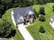Aerial view showcasing a two-story home with a well-kept lawn, long driveway, and attached garage at 4966 Riverview Dr, Harrisburg, NC 28075