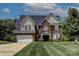 Beautiful two-story brick home featuring a manicured lawn and attached two-car garage at 4966 Riverview Dr, Harrisburg, NC 28075