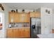 Bright kitchen with light wood cabinets, stainless refrigerator, and access to the dining area at 4966 Riverview Dr, Harrisburg, NC 28075