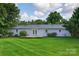 Well-maintained backyard showcasing a charming patio, lush green lawn, and the rear facade of the home at 5445 Creekwood Dr, Salisbury, NC 28147