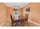 Dining room with a wood table, chandelier, and neutral paint and tile flooring at 5445 Creekwood Dr, Salisbury, NC 28147