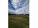 Expansive green field surrounding a well-maintained home under a partly cloudy sky, highlighting peaceful rural living at 5707 S Rocky River Rd, Monroe, NC 28112