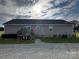 Back of house with patio, sliding glass door, windows and charcoal-colored siding at 5707 S Rocky River Rd, Monroe, NC 28112